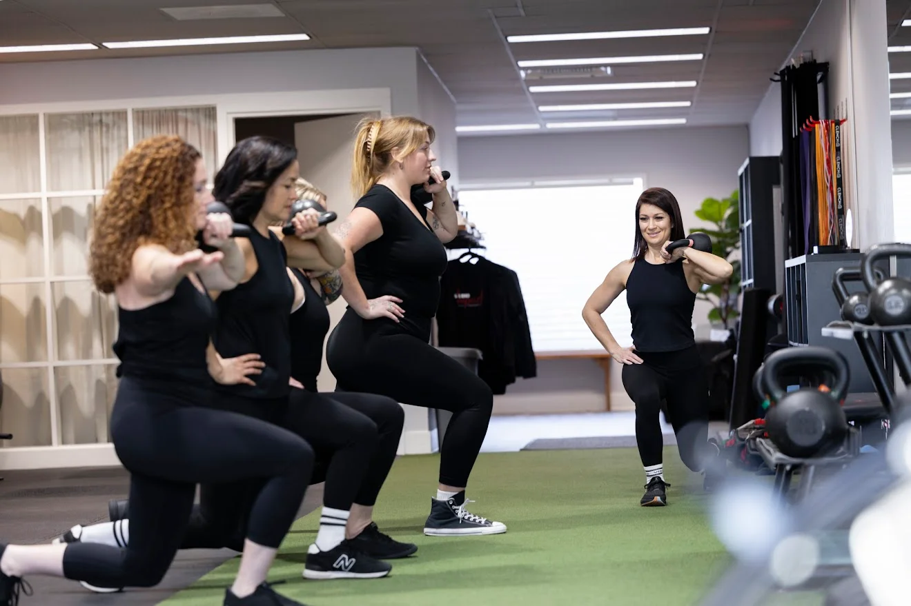 Coach Stephanie leading a small group training session at Studio Impact